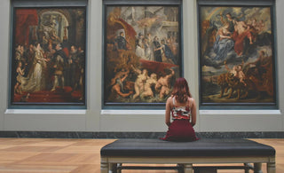 woman looking at famous paintings - top investments to make money